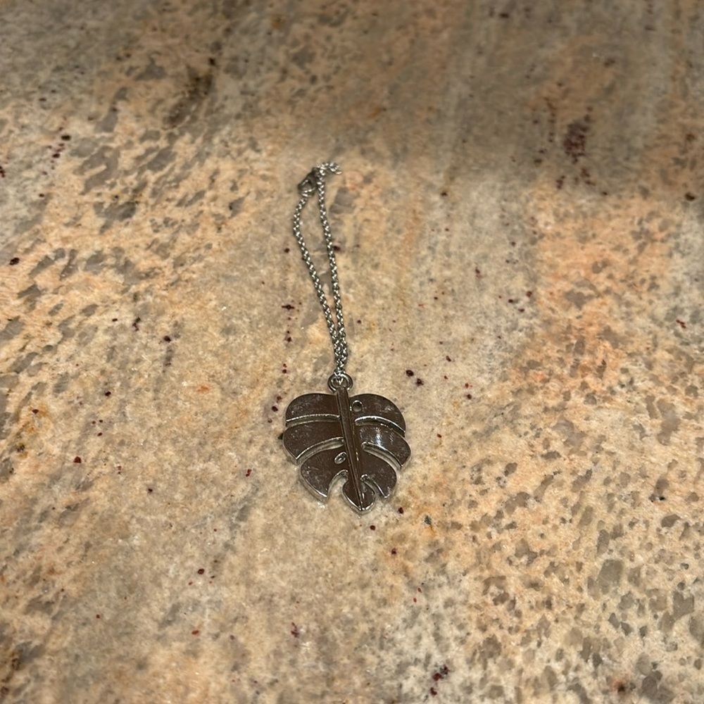 Woman's bracelet with a silver plated leaf charm at the end of the bracelet